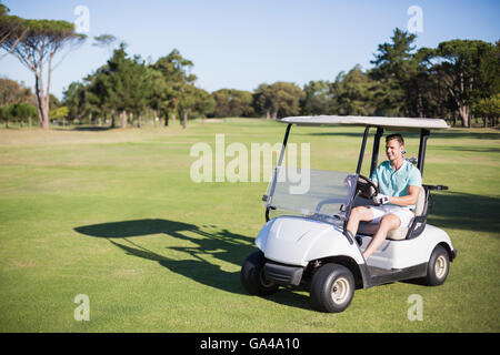 Voller Länge glücklich Golfer Mannes Golfbuggy fahren Stockfoto