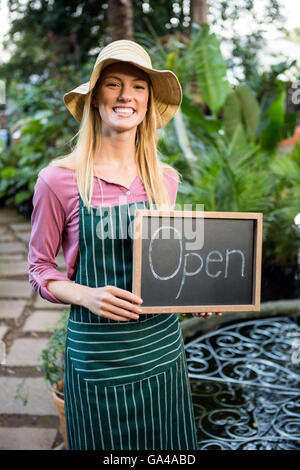 Porträt der schönen Gärtnerin mit open Text auf Tafel im Garten Stockfoto