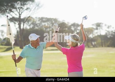 Fröhliche ältere Golfer paar geben hohe fünf Stockfoto