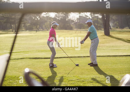 Reifer Mann lehrt Frau um Golf zu spielen Stockfoto