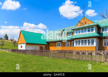 Typisches Holzhaus auf grüner Wiese in Chocholow Dorf, Tatra-Gebirge, Polen Stockfoto