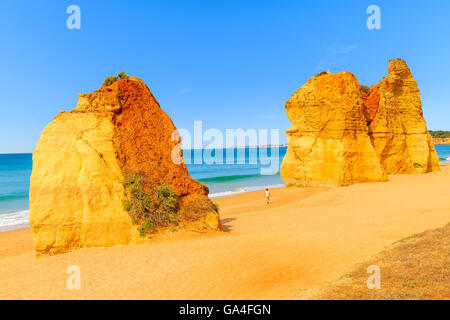 Touristischen Wandern zwischen Felsen am schönen Strand Praia da Rocha, Region Algarve, Portugal Stockfoto