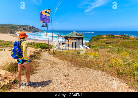 AMADO BEACH, PORTUGAL - 15. Mai 2015: Junge Frau Tourist am Wanderweg nach Praia do Amado Beach im Frühjahr, die Region Algarve, Portugal. Diese Gegend ist berühmt Surfen in ganze Portugal statt. Stockfoto