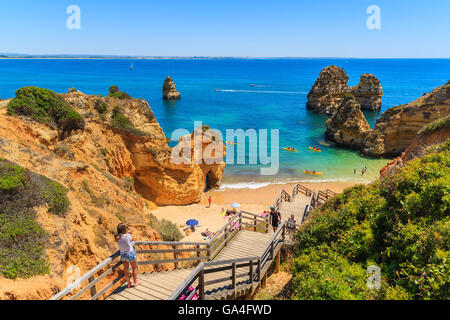 Unbekannte junge Frau Touristen nehmen Foto von schönen Strand Praia Do Camilo, Portugal Stockfoto