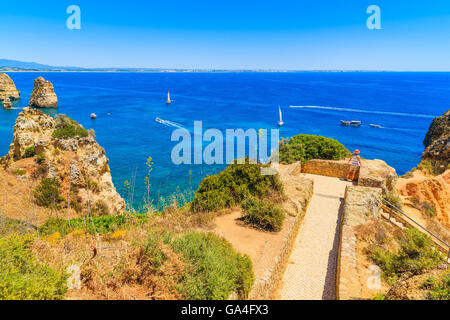 Junge Frau touristischen stehend auf einem Aussichtspunkt und mit Blick auf Meer, Ponta da Piedade, Portugal Stockfoto