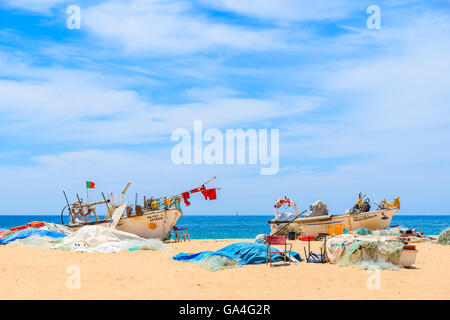 ARMACAO DE PERA BEACH, PORTUGAL - 17. Mai 2015: zwei typische bunte Fischerboote am Sandstrand gegen blaue Meer in Armacao de Pera Küstenstadt, Portugal. Stockfoto