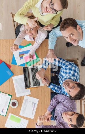 Unterschiedliche Menschen arbeiten mit Laptop und Finanzberichte Stockfoto
