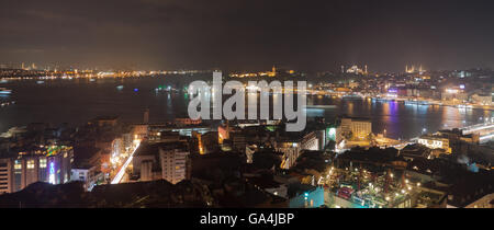 Skyline Istanbuls vom Galata-Brücke bei Nacht mit Kreuzfahrtschiffen, Türkei Stockfoto
