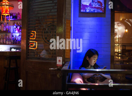 Chinesische Jugendliche spielen Sie mit ihren Smartphones und soziale Netzwerke in Peking, China Stockfoto