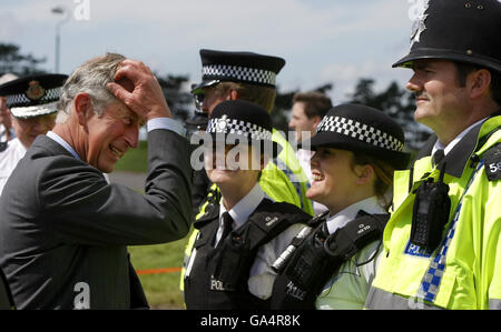 Der britische Prinz Charles trifft auf Polizisten der Gloucestershire Constabulary, die während der jüngsten Überschwemmungen in der Gegend von Gloucester auf der Pferderennbahn Cheltenham Hilfe geleistet haben. Stockfoto