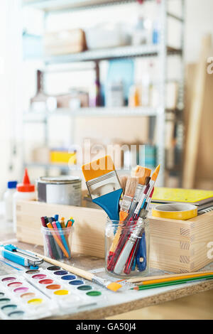 Pinsel und crafting-Vorräte auf dem Tisch in einer Werkstatt. Stockfoto