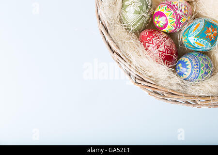 glänzende bunte Ostereier im Weidenkorb Stockfoto