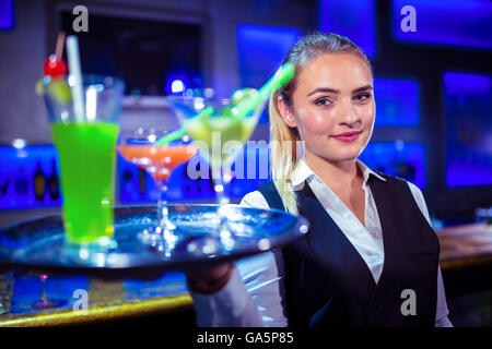 Porträt von hübschen Barkeeper halten Serviertablett mit cocktails Stockfoto