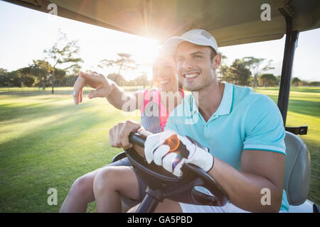 Lächelnd Golfer Frau zeigt durch den Menschen Stockfoto