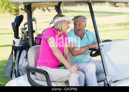 Paar sitzt im Golfbuggy Stockfoto