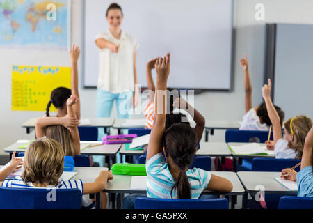 Lehrerin zeigt Schüler mit erhobenen Händen Stockfoto