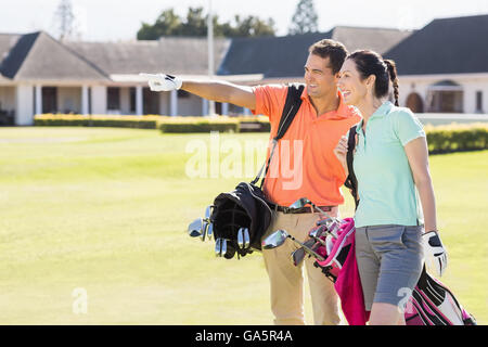 Mann zeigte während des Gehens von Frau Golf Tragetasche Stockfoto