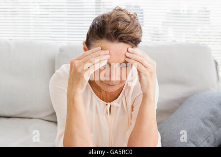 Reife Frau, die unter Kopfschmerzen leiden Stockfoto