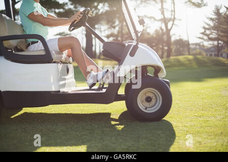 Geringer Teil der Golfer Mann Golfbuggy fahren Stockfoto