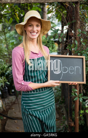 Porträt von glücklich Gärtner mit open Text auf Tafel im Garten Stockfoto