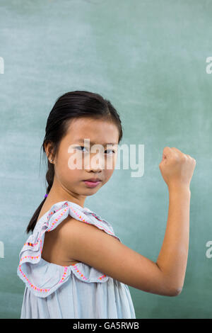 Porträt von Mädchen zeigt Faust im Klassenzimmer Stockfoto