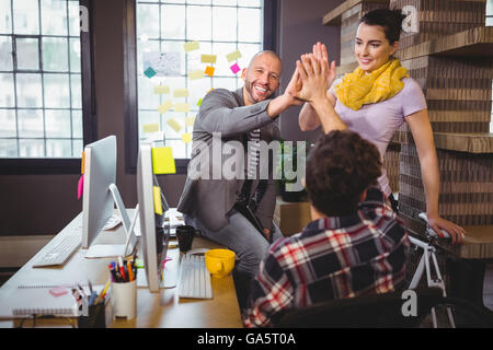 Glückliche Mitarbeiter hohe fiving Stockfoto