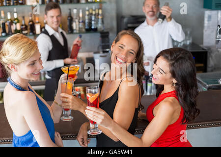 Glücklich Freundinnen mit Glas cocktail am Tresen Stockfoto