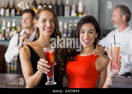 Zwei schöne Frauen halten Cocktailglas Stockfoto