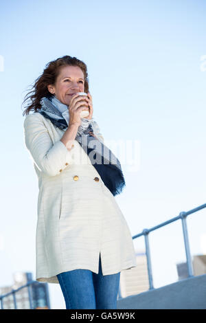 Frau Kaffee trinken gegen klarer Himmel Stockfoto