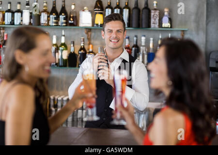 Zwei Frauen, die cocktail zwar einen Kellner mit cocktail-Shaker cocktail Zubereitung Stockfoto