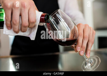 Barkeeper gießt Wein im Glas Stockfoto