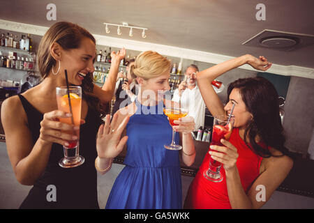 Freundinnen mit Glas cocktail beim Tanzen Stockfoto