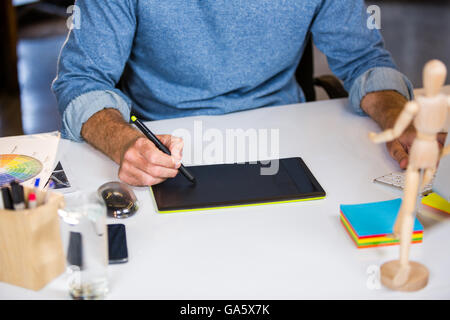 Foto-Editor mit Grafiktablett am Schreibtisch Stockfoto