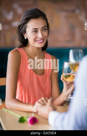 Paar Hand in Hand beim Glas Wein Stockfoto