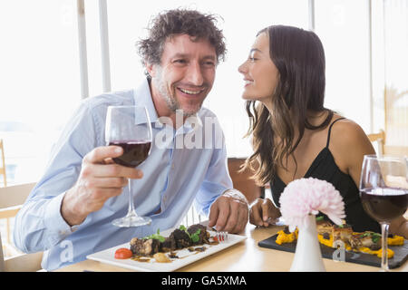 Frau auf Flüstern mans Ohr Stockfoto