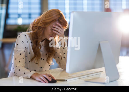 Betonte Geschäftsfrau leiden unter Kopfschmerzen im Büro Stockfoto