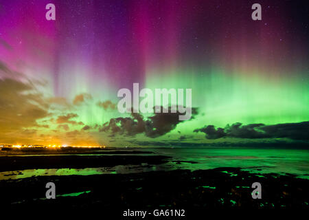 Ein starker Sonnensturm erzeugt ein helles Display des Nordlichts über die küstennahen Dorf Beadnell in Northumberland. Stockfoto