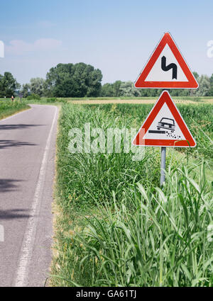 Gefährliche Schulter europäischen Schild Kiesweg in italienischen Landschaft am Himmelshintergrund Stockfoto