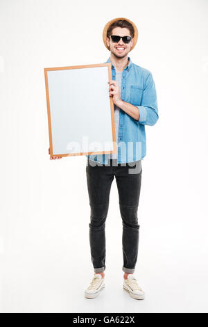 Close-up Portrait von einem lächelnden bärtiger Mann hält leere Brett auf dem weißen Hintergrund isoliert Stockfoto