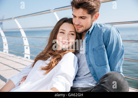 Porträt eines jungen glücklich schönen Paares sitzen im freien Stockfoto