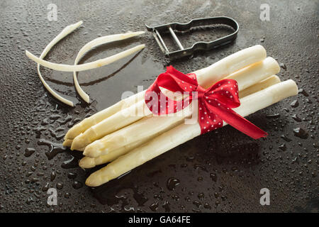 Reihe von weißen Spargel schälen, Schäler und Wasser Tropfen Stockfoto