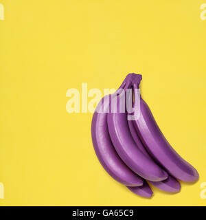 Haufen von Violet Bananen auf gelbem Hintergrund. Stockfoto