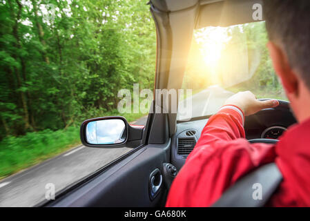 Männliche Fahrer fährt ein Cabrio auf der Landstraße. Der Blick aus der Kabine, Rückansicht, innen. Stockfoto