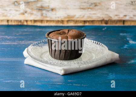 Coulant Schokolade Kuchen, gebacken auf blaue Holz in rustikaler Umgebung Stockfoto