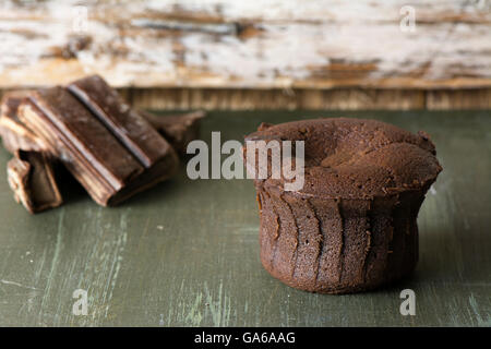 Coulant Schokolade Kuchen, gebacken auf blaue Holz in rustikaler Umgebung Stockfoto