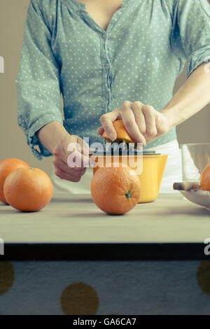 Frau quetschen Orangen auf einem Tisch Vorbereitung Saft, flach geschlossen Stockfoto