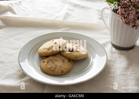 Heidelbeeren-Cookies auf einem weißen Teller auf Tischdecke Stockfoto