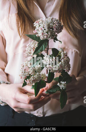 Stilvolle Frau rosa Blumenstrauß in ihren Händen hält Stockfoto