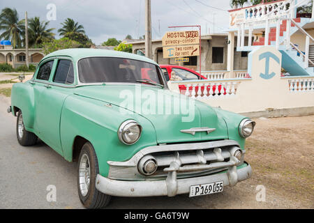 Vintage Chevy Taxi parkte vor ein familiär geführtes Haus mit Zimmer zu vermieten an Touristen in Playa Larga, Kuba. Stockfoto