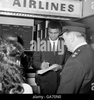 Der Schwergewichtsweltmeister Muhammad Ali (Cassius Clay) unterzeichnet Autogramme, als er den Londoner Flughafen nach Ägypten verlässt, wo er Gast des Hohen Rates für islamische Angelegenheiten sein wird. Stockfoto